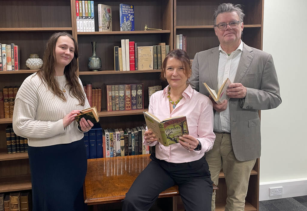 Quire Auctions founders in front of bookshelves